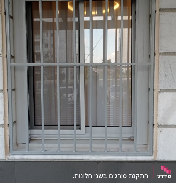 חלון עם סורגים מתכתיים על קיר אבן